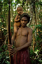 Portrait of Hagahai hunter holding bow & arrows and child, Papua New Guinea 1992