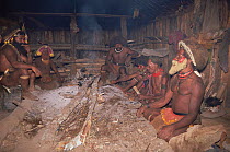 Huli wigman in hut around fire, in traditional clothing, Papua New Guinea 1991