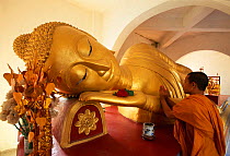 Reclining Buddha and novice Monk, Wat Pha Baat Tai, Luang Prabang, Laos, South East Asia.