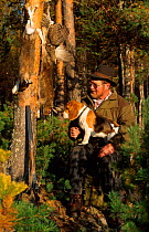 Hunter with dog + gun and catch of Capercaillie and Hare. Vatnebrynvannet lake, Norway