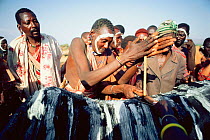 Maasai 'Emowuo-o-lkiteng ceremony, Kedong Valley, Rift valley, Kenya. Lighting ceremonial fire on back of ritual ox. 1985