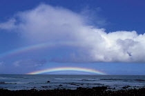 Y-10401 Rainbow on horizon over sea with dark clouds above