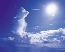 Y-1002 Cumulonimbus clouds in blue sky with sun shining above sea