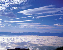 Y-8901 Aerial view of clouds above and below mountain peaks