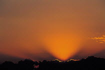 Y-8804 Sun setting behind dark clouds in evening