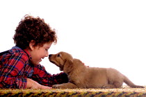 ic-04406 Child nose to nose with Golden retriever puppy.