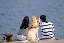 ic-04502 Couple with Golden retriever looking out to sea.