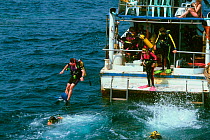 Divers jumping from boat into the sea. Andaman sea, Thailand