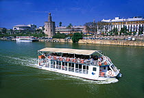 Seville Tourist boat on river with the Torre del Oro behind, Andalucia, Spain