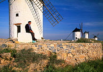 Man sitting in front of windmill, Consuegra, Spain, Europe