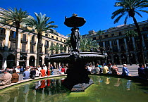 People sitting by fountain in Placa Real, Barcelona, Catalunya, Spain