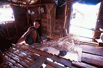 Bajau woman weaves sleeping mat, Borneo, Malaysia