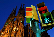 Traffic lights with walk sign lit, next to Gaudi's La Sagrada Familia, Barcelona, Catalunya, Spain