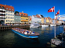 Nyhavn Waterfront District with cafes and restaurants, and ferry boat, Copenhagen, Denmark