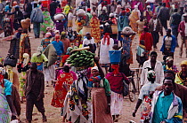 Crowd of people with lady carrying bananas on head, Rugarama, Ruhengeri, Rwanda