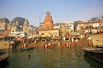 People on ghats bathing in sacred river Ganges, Varanasi / Benares, Uttar Pradesh, India