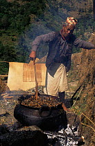 Man boiling up honeycomb to remove wax, Nepal