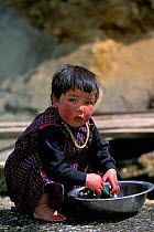 Bhutanese child doing laundry near Tongsa, Central Bhutan