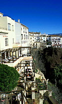 People eating on balconies of houses in hilltop village, Ronda, Andalucia, Spain