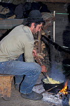 Shepherd preparing polenta (staple food) Transylvania, Romania