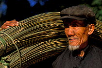 Hani man carrying split bamboo canes, Huangcouba village, Yuanuyang, Yunnan, China Hani
