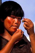 Campa indian painting her face with achiote plant dye, Lower Urubamba river, Amazonia, Peru