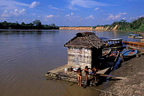 Floating house with children jumping into river, Tambopata river, Amazonia, Peru