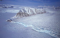 Heavily crevassed glacier (right) meets frozen sea ice (left) Svalbard, Norway