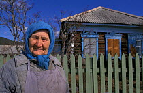 Woman outside wooden house, Rougir village, Olhkon Is, Lake Baikal, Siberia, Russia