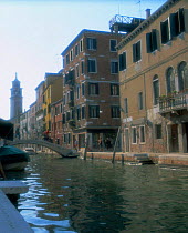 Houses beside the Rio di San Barnaba canal with tower of Carmini church, Venice, Italy