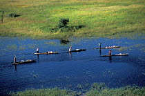 Local people moving on mokoros, traditional boats of the Okavango delta. Botswana.
