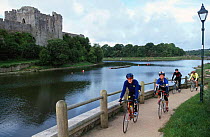 Cyclists on Celtic bicycle path, by river in Pembrokeshire, Wales, UK.