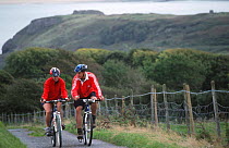 Cyclists biking on Celtic trail, Pembrokeshire, Wales.