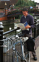Cyclist examines route map on Hull to Fakenham cycle path, England
