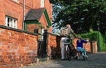 Man taking child to school on bicycle, Leicestershire, England
