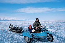 Cameraman Doug Allan in motorbike sidecar with Russian guide. Lake Baikal, Siberia