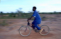 Local giraffe guide on bicycle. Sahel, Niger.