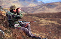 Deer stalker searching with binoculars for deer. Knoydart, Scotland, UK