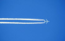 Vapour trails left in blue sky by jet aircraft. Scotland, UK