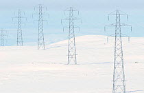 Electricity pylons cross snowy landscape, Central highlands, Scotland, UK