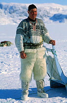 Dog handler on Giant Kangia fjord, Disko Bay, Greenland. Wearing polar bear skin trousers