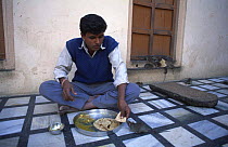 Temple keeper sharing food with 'holy' Black rat (Rattus rattus) Deshnoke, Rajasthan, India 2004