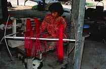 Woman weaving coloured silk threads, E-Sarn, Thailand