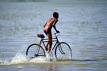 Naked boy riding bicycle in Lake Ziway, Ethiopia, 2003