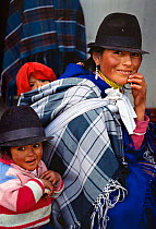 Quechua indian mother carrying baby on her back, Zumbahua, Ecuador.