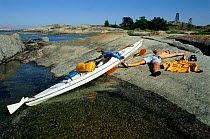 Man resting on Sea kayaking holiday, Sweden.
