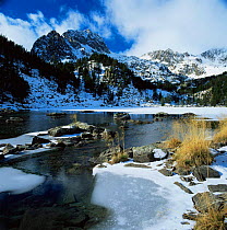 Partly frozen lake below Aigues Tortes i Estany Sant Maurici NP, The Pyrenees, Lerida, Catalonia, Spain. Europe