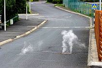 Steam rising through road in town heated by geothermal activity, Hveragerdi, Iceland