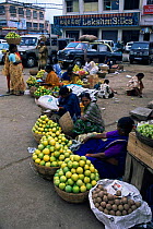 Women selling oranges beside road, Mysore, Karnataka, India