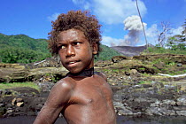 Local boy collecting water, Mount Yasur erupting in background, Tanna, Vanuatu
